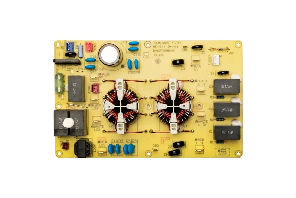 Platine von Brötje mit verschiedenen elektrischen Komponenten, darunter Induktivitäten, Kondensatoren und Schalter, auf gelbem Trägerboard.