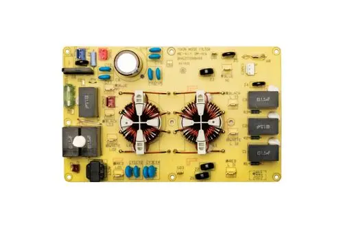 Platine von Brötje mit verschiedenen elektrischen Komponenten, darunter Induktivitäten, Kondensatoren und Schalter, auf gelbem Trägerboard.