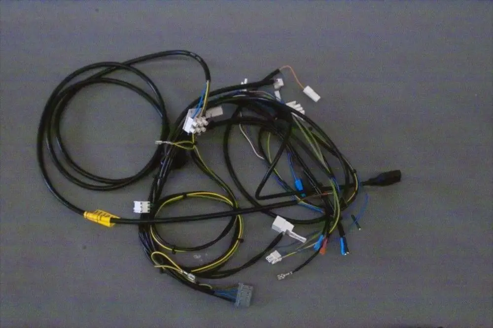 Kabelbaum von Brötje mit mehreren elektrischen Leitungen und Steckverbindern, leicht verworren auf einem grauen Untergrund dargestellt.