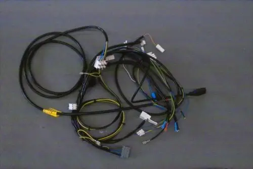Kabelbaum von Brötje mit mehreren elektrischen Leitungen und Steckverbindern, leicht verworren auf einem grauen Untergrund dargestellt.