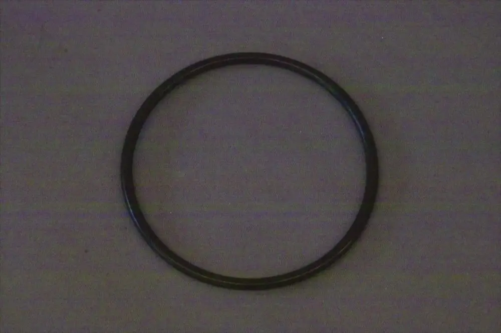 Schwarzer O-Ring auf grauem Hintergrund, möglicherweise für technische Anwendungen in Brötje-Produkten verwendet.