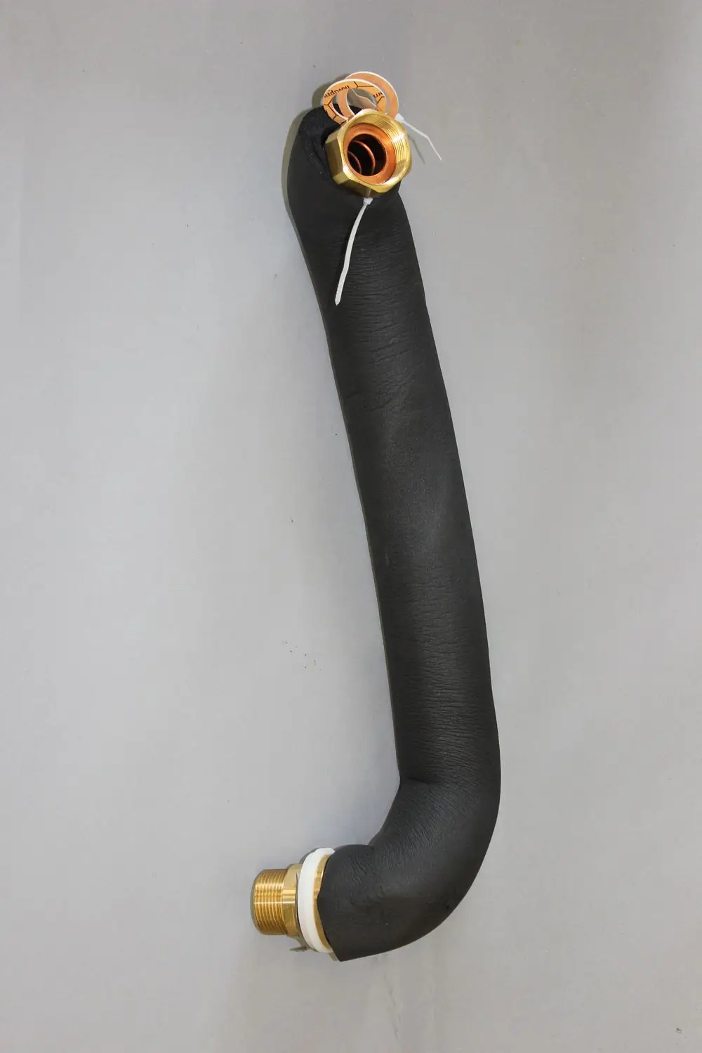 Schwarzer, gebogener Schlauch mit zwei Metallanschlüssen, hergestellt von Brötje. Der Schlauch ist mit einer schwarzen Isolierung versehen und hat eine Kunststoffdichtung.