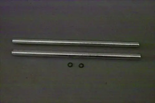 Zwei metallische Bolzen von Brötje, entlang einer grauen Unterlage angeordnet, mit zwei kleinen Ringen darunter.