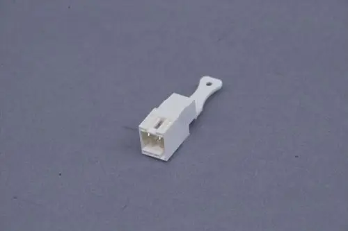 Weißer Stecker auf grauem Hintergrund, möglicherweise von Brötje, mit einfachem Design und zwei Kontaktöffnungen.