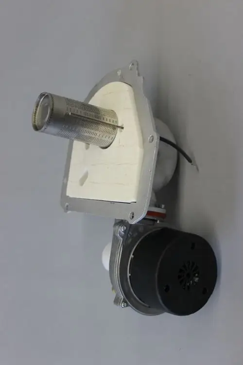 Brötje Brennereinheit mit zylindrischem Element und Motor. Die Komponente zeigt einen Metallring und eine Montageplatte aus hellem Material.