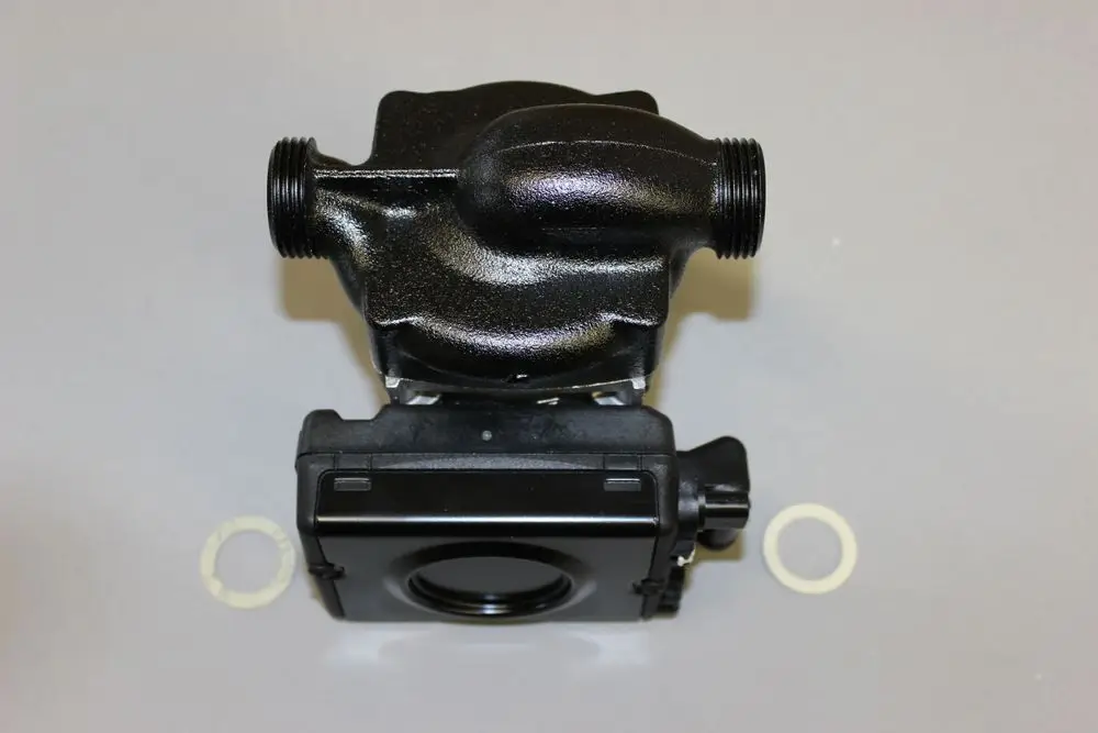 Brötje Pumpe mit zwei Anschlussgewinden, schwarzem Gehäuse und einem Stecker. Die Pumpe hat ein unteres Gehäuseelement und zwei Dichtungsringen auf dem Tisch platziert.