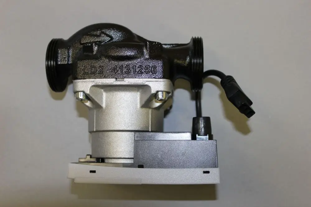 Heizungsumwälzpumpe von Brötje, ausgestattet mit Anschlussleitungen und einem elektrischen Anschluss. Gehäuse in schwarzer und silberner Farbe.