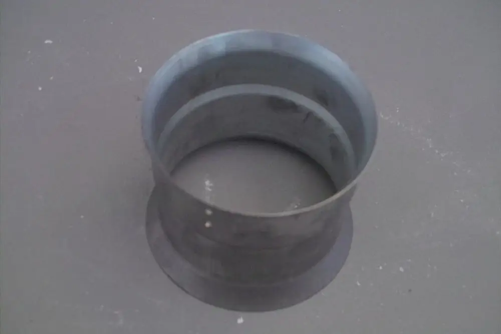 Zylindrisches Bauteil aus Metall, mit zwei unterschiedlichen Durchmessern, vermutlich Teil eines Heizsystemes von Brötje.