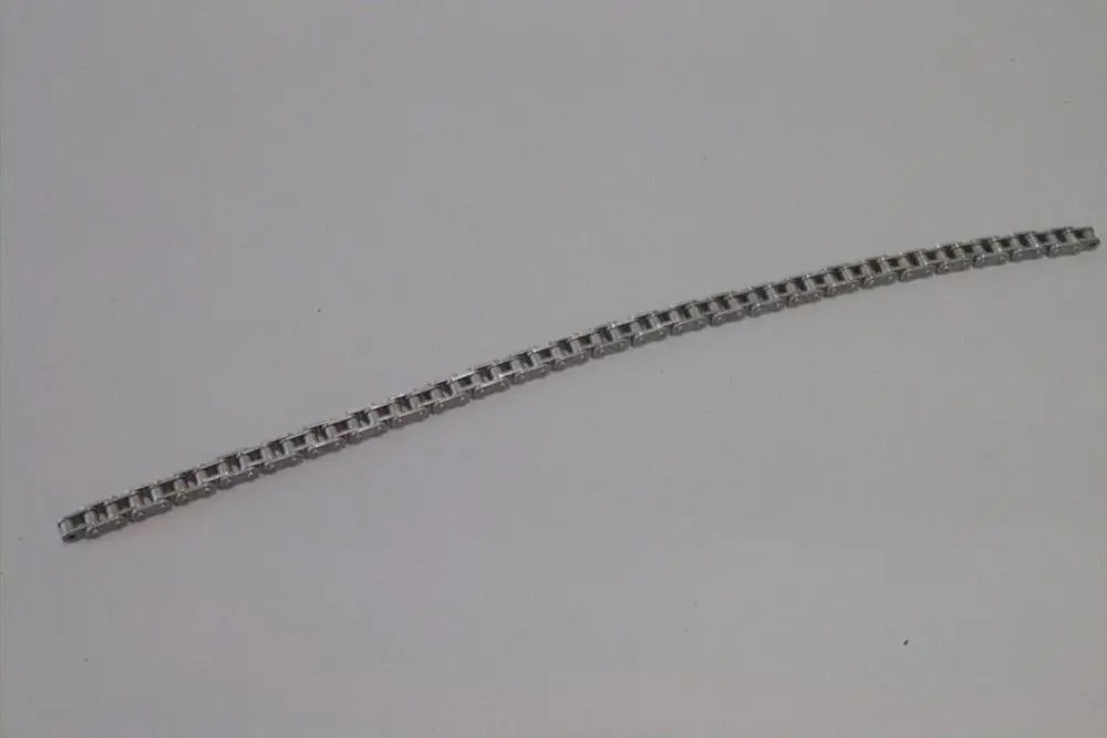 Brötje Rollenkette, bestehend aus einer Reihe von miteinander verbundenen Elementen, auf weißem Hintergrund liegend.