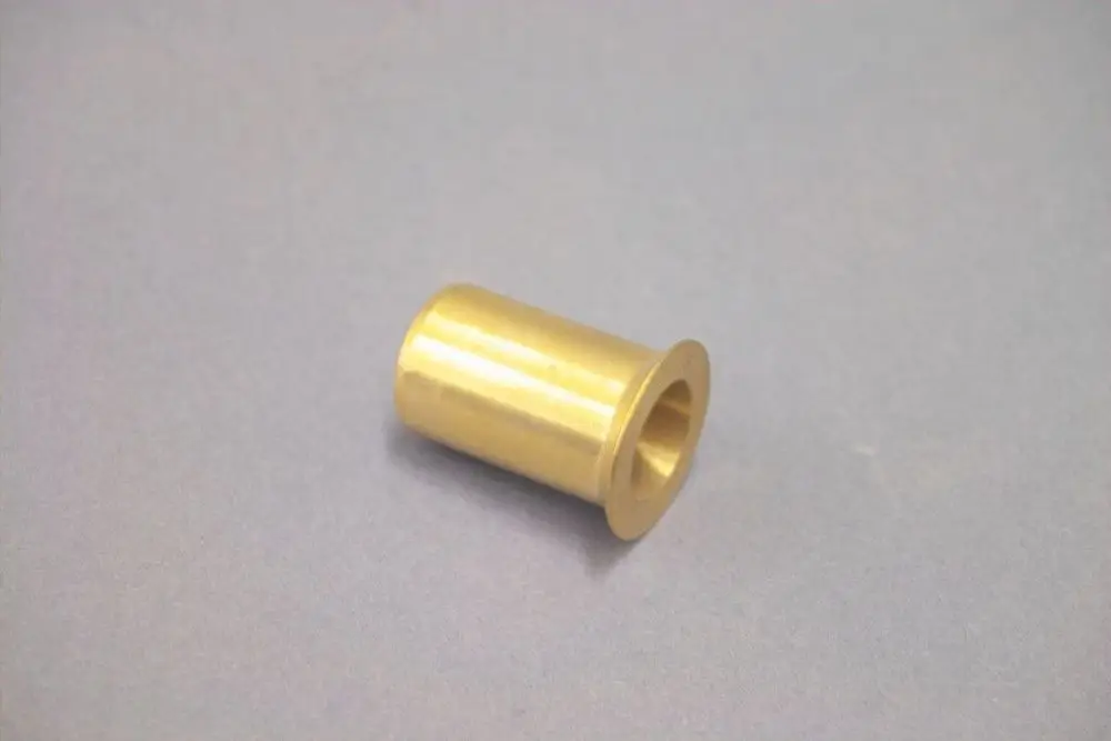 Brötje Düse in zylindrischer Form aus Metall, mit einem breiten Rand an einem Ende und einem hohlen Kern, auf grauem Hintergrund.