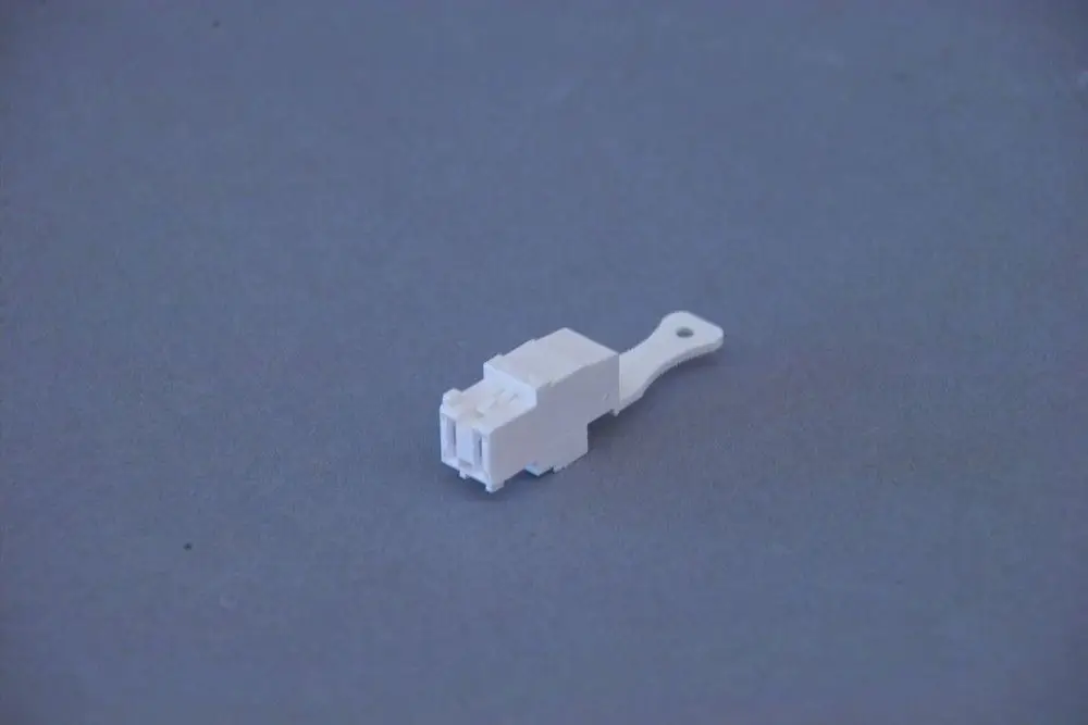 Weiße Kunststoffbuchse mit einer Halterung, möglicherweise Teil einer elektrischen Verbindung, von der Marke Brötje.