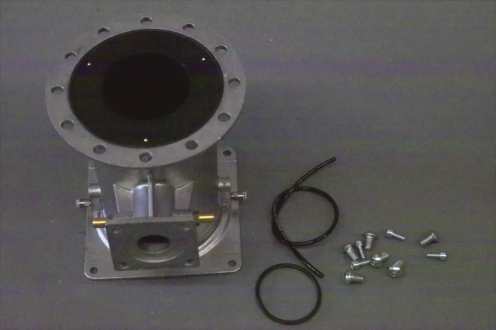 Brötje Venturi Einheit aus Metall mit ovaler Öffnung, mehreren Schrauben und Dichtungen in zerlegtem Zustand, auf grauem Untergrund dargestellt.