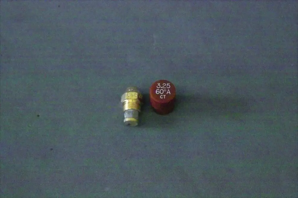 Brötje Düse in silberner Farbe, mit einem runden roten Deckel, auf grauem Hintergrund. Die Düse hat ein sichtbares Gewinde und eine flache Unterseite.