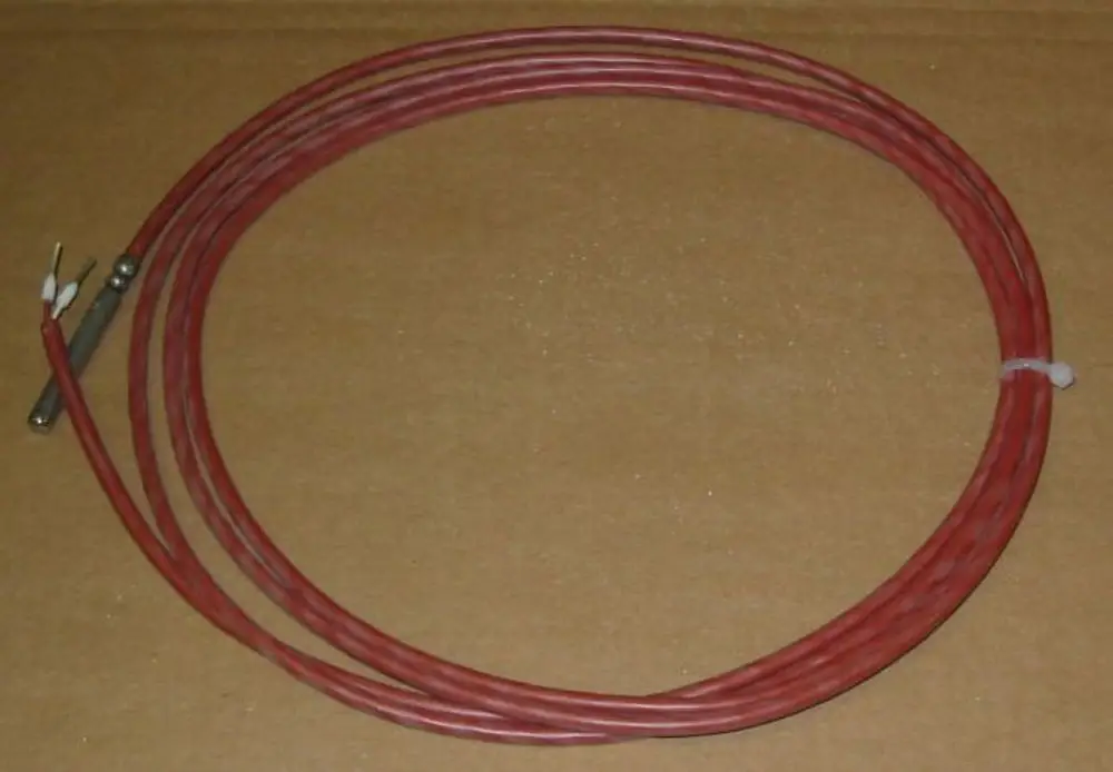 Brötje Sensor mit rotem Kabel, mehrere Drähte mit Anschlussklemmen und einem metallischen Teil. Verwendung möglicherweise für Temperaturmessungen in Heizsystemen.