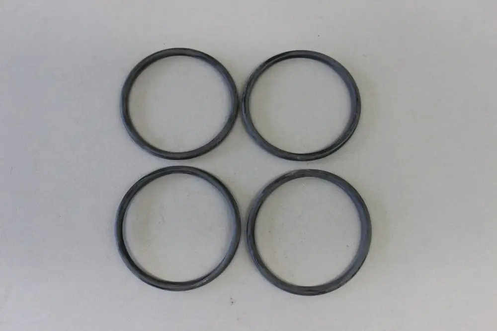 Vier schwarze O-Ringe, angeordnet in zwei Reihen, auf einer hellen Oberfläche. Sie scheinen für technische Anwendungen, möglicherweise von der Marke Brötje, geeignet zu sein.