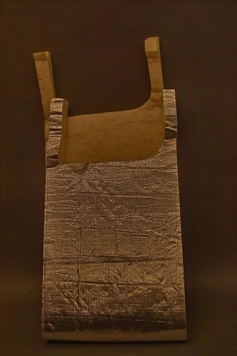 Brötje-Isolationsmatte mit silberner Oberfläche, in Form einer aufrechten Tasche mit zwei Griffen. Eignet sich zur Dämmung von Kesselkörpern.