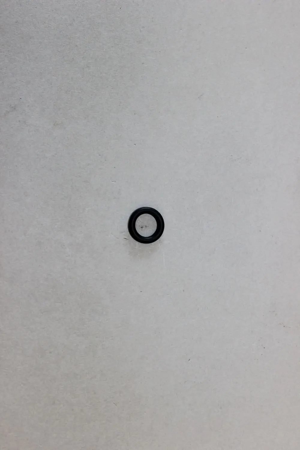 Schwarzer O-Ring auf grauem Untergrund, möglicherweise für technische Anwendungen, hergestellt von Brötje.