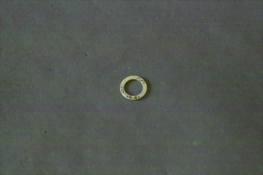 Runde Dichtung aus Metall in neutralem Farbton, mittig mit einer Öffnung, auf grauem Untergrund. Gehört zur Brötje Gasventil-Baureihe.