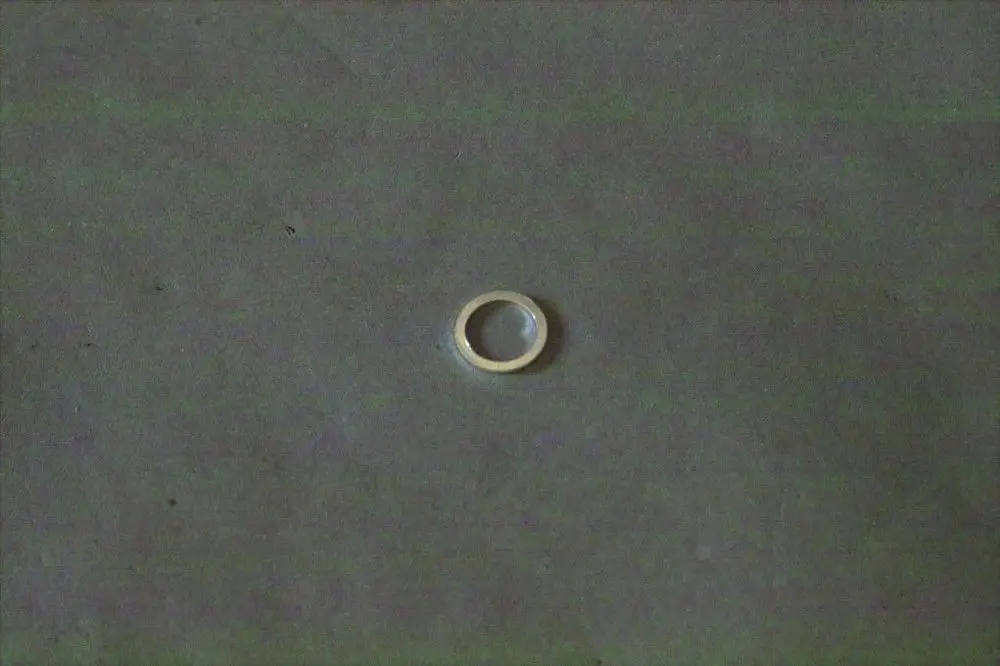 Brötje-Dichtung aus Metall, kleiner ringförmiger Artikel auf grauem Untergrund.
