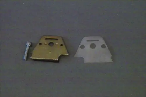 Brötje Druckregulierung mit zwei Metallteilen und einer Schraube auf grauem Hintergrund. Die linke Komponente ist goldfarben, die rechte ist silberfarben und flach.