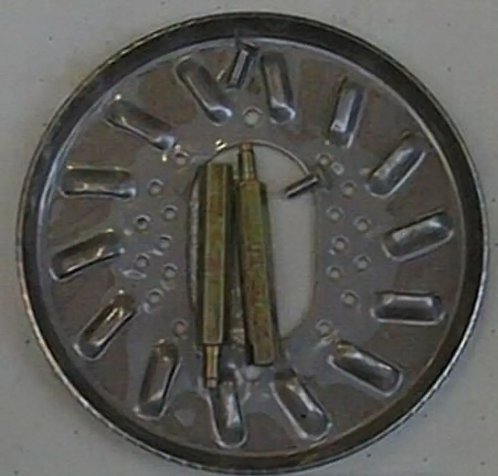 Metallene Stauscheibe mit mehreren Aussparungen und zwei goldfarbenen Stiften in der Mitte, geeignet für Anwendungen von Brötje.