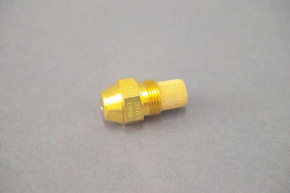 Brass nozzle with a beige porous tip, used in heating systems, likely by Brötje, placed on a gray surface.