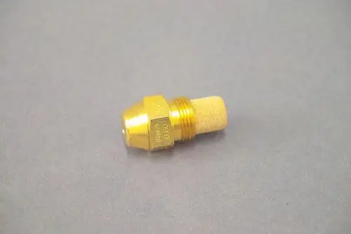Brass nozzle with a beige porous tip, used in heating systems, likely by Brötje, placed on a gray surface.