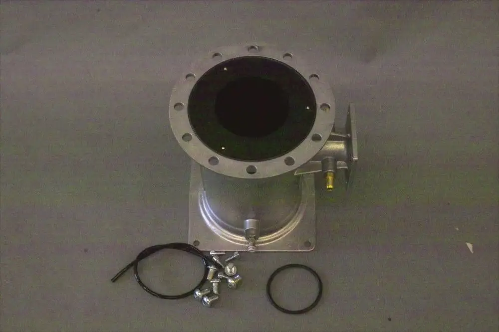 Brötje Venturi-Einheit aus Metall mit runder Öffnung oben, seitlichem Anschluss und Zubehörteilen wie Schrauben und O-Ring auf grauem Untergrund.