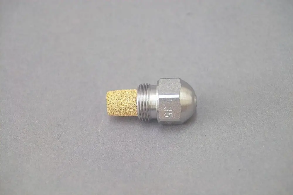 Brötje Düse aus Metall mit porösem Aufsatz, konische Form an einem Ende, Gewinde auf der anderen Seite, stehende Position auf grauem Untergrund.