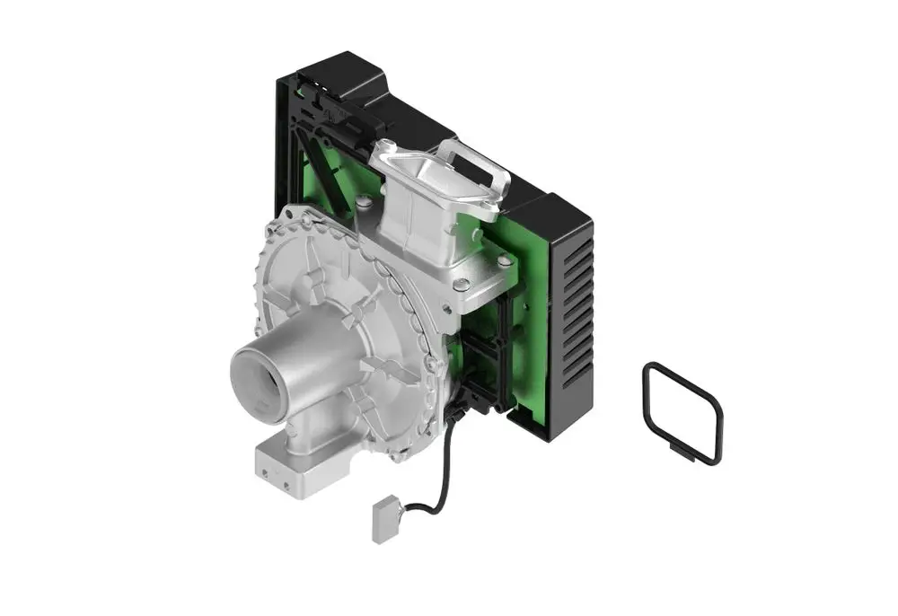 Brötje Platine-/Ventilatoreinheit, bestehend aus einem silbernen Gehäuse mit integriertem Ventilator und einer schwarzen Rückwand. Neben dem Bauteil ist ein dichtendes Element sichtbar.