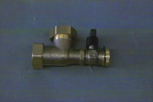 Brötje Winkelstück aus Metall mit zwei Anschlussgewinden und einem Kugelhahn, auf einer grauen Unterlage abgebildet.