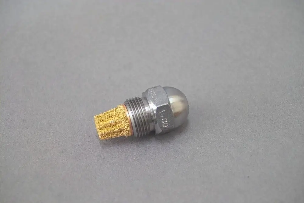 Brötje Düse mit metallem Gehäuse und goldfarbener Filteröffnung, auf grauem Hintergrund liegend, für Anwendungen in fluidischen Systemen.
