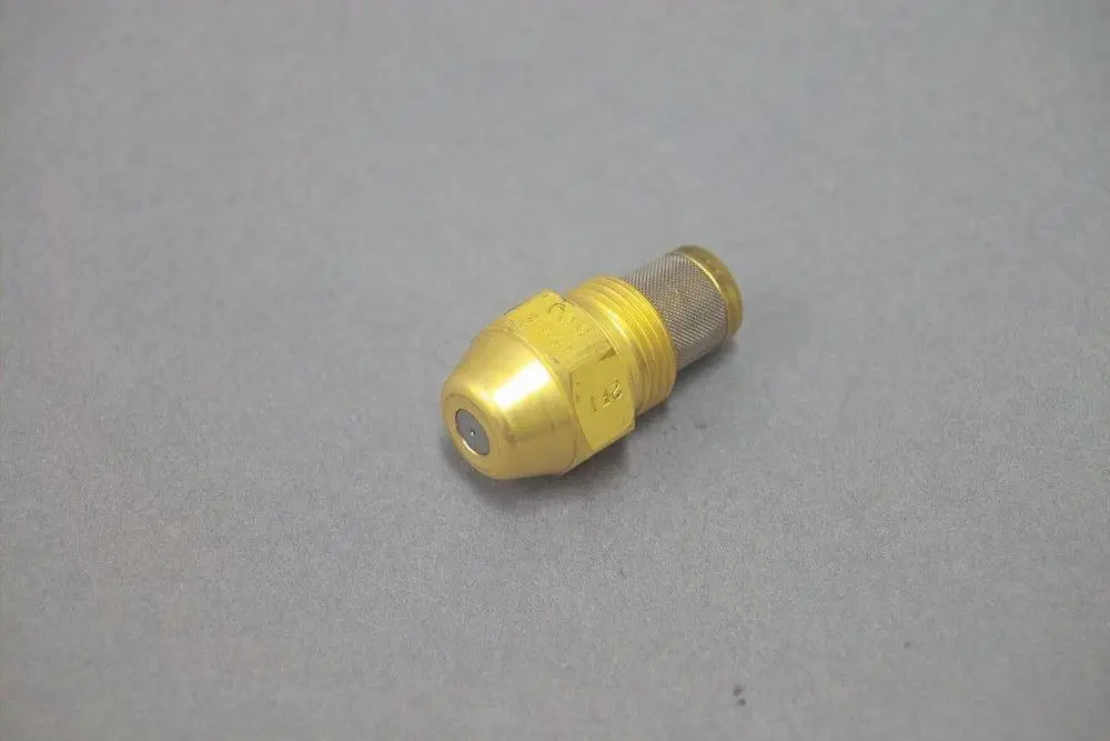 Brötje Düse in goldener Farbe, mit einem runden Ende und Gewindeteil, liegt auf einer grauen Oberfläche. Das Produkt wirkt robust und einfach zu montieren.