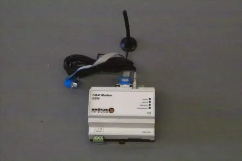 BRÖTJE GSM-Modem mit Antenne, Kabelanschlüssen und LED-Anzeigen zur Statusüberprüfung. Die Einheit ist in einem kompakten Design und für Systemkommunikation konzipiert.