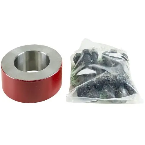 Rotes Ausgleichsstück von Grundfos mit einem metallischen Innenring, daneben eine Tüte mit schwarzen Befestigungsteilen.