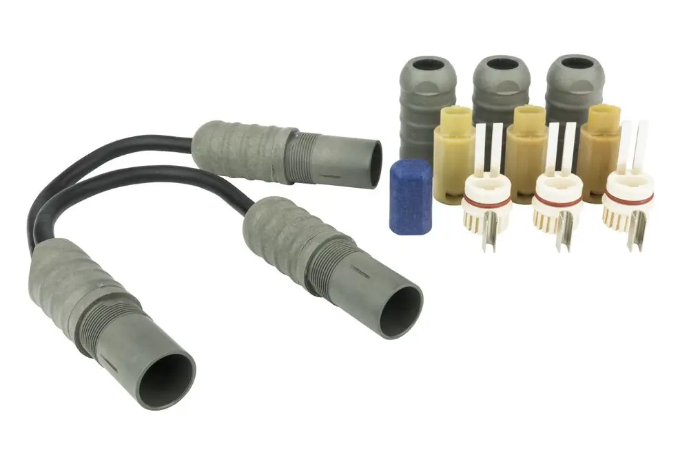 Drei graue Connecto T-Abzweige und mehrere (weiße, gelbe und graue) Anschlussstecker für Heizbänder von Danfoss auf hellem Untergrund angeordnet.
