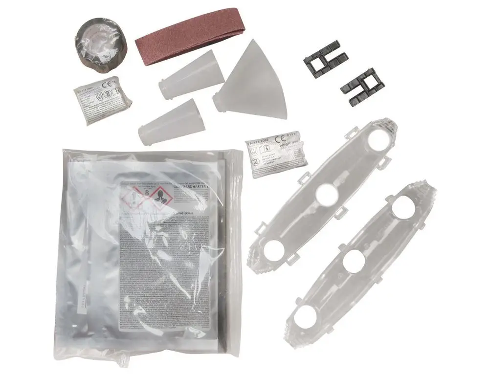 Zubehörset von Grundfos für Unterwasserpumpen, bestehend aus verschiedenen Teilen wie Kabelverbindern, Schalen, Sandpapier und einem Sicherheitsdatenblatt in einer Verpackung.