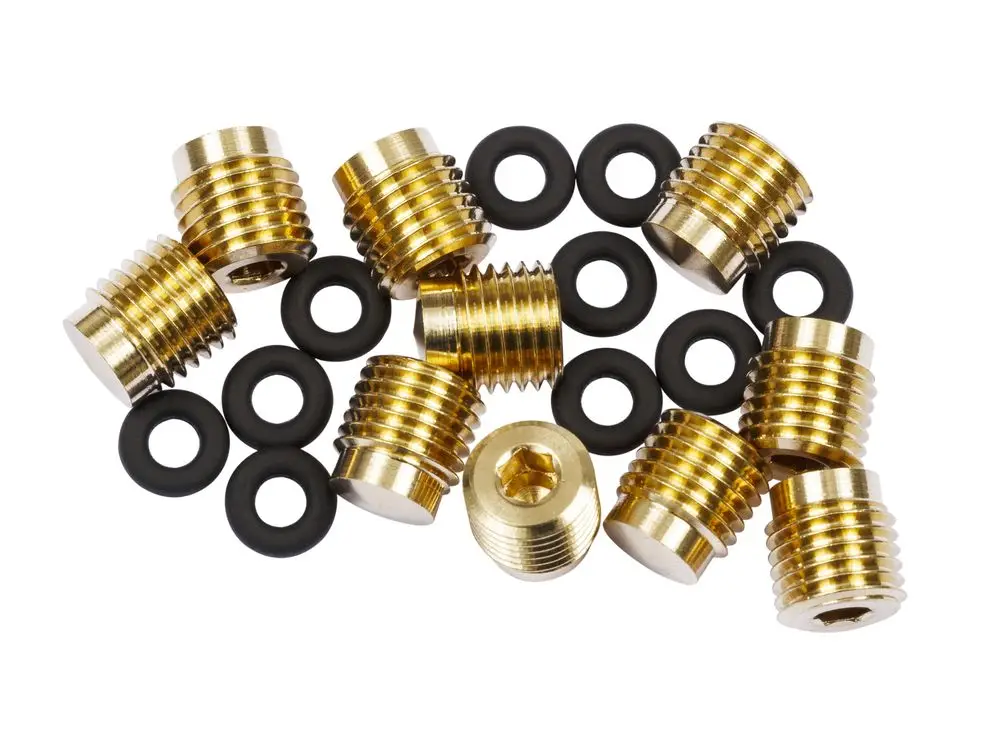 Zwei Reihen goldfarbener Verschlussstopfen und schwarze O-Ringe. Teile sind für Danfoss-Produkte geeignet und liegen in einer chaotischen Anordnung auf einem weißen Hintergrund.