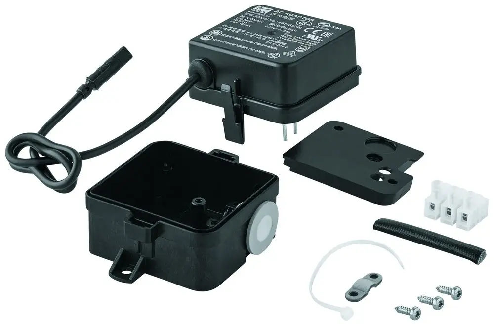 Schwarzes Schaltnetzteil von Grohe, bestehend aus einem Gehäuse, abnehmbarer Abdeckung, Kabel, Anschlussklemmen und Montageschrauben, auf einem weißen Hintergrund angeordnet.