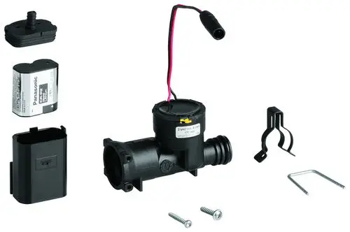 GROHE Generator mit einem schwarzen Gehäuse, Kabelanschluss, und Zubehörteilen wie Schrauben, Halterungen und einem Batteriefach in einer übersichtlichen Anordnung.