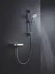 Grohe Handbrause an einer Wandmontage, mit flexiblem Schlauch. Wasser spritzt in einem gleichmäßigen Strahl, neben einem Steuerungselement zur Regulierung.