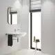 Weiße Wand mit eingebautem Waschbecken und Spiegel von Grohe. Handtuchhalter und ein kleiner Tisch neben dem Fenster. Helle, minimalistische Gestaltung.