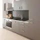 Küche mit grauen Schränken, Edelstahlgeräten und schwarzem Waschbecken. Grohe Armatur mit hohem Auslauf über der Spüle. Holzplatte als Arbeitsfläche.