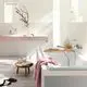 Badezimmeransicht mit einem Grohe-Wasserhahn an der Wand, einem freistehenden Waschbecken, einer Badewanne und einer Holzablage mit Pflegeprodukten. Sanfte Beleuchtung und minimalistisches Design.