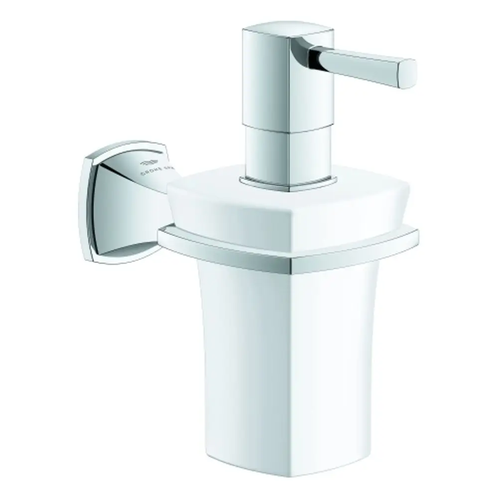 Chromfarbener Seifenspender von Grohe mit keramischem Halter. Der Dispenser hat eine quadratische Form und einen Hebel zum Betätigen, montiert an der Wand.