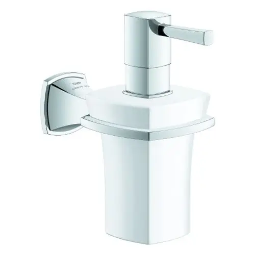 Chromfarbener Seifenspender von Grohe mit keramischem Halter. Der Dispenser hat eine quadratische Form und einen Hebel zum Betätigen, montiert an der Wand.