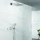Grohe Handbrause in chrom, montiert an der Wand, mit einem festen Duschkopf und einer Handbrause. Weiße Wandverkleidung aus Marmor im Hintergrund.