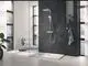 Badezimmer mit moderner Dusche, ausgestattet mit einer Grohe Handbrause. Sichtbare Fliesenfläche und große Fenster sorgen für Helligkeit im Raum. Pflanze und Sitzmöbel ergänzen die Einrichtung.