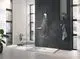 Dusche mit transparenter Glasabtrennung, schwarzer Wandverkleidung und moderner Handbrause von Grohe. Sichtbare Duschelemente mit Modernem Design.