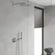Duschsystem mit runder Kopfbrause und Thermostatmischer, Wandmontage in einem modernen Badezimmer mit grauen Fliesen und Fenster mit Holzjalousien, von der Marke Grohe.